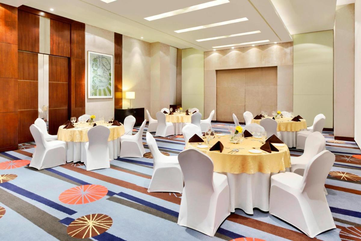 a conference room with tables and white chairs at Courtyard by Marriott Pune Hinjewadi in Pune