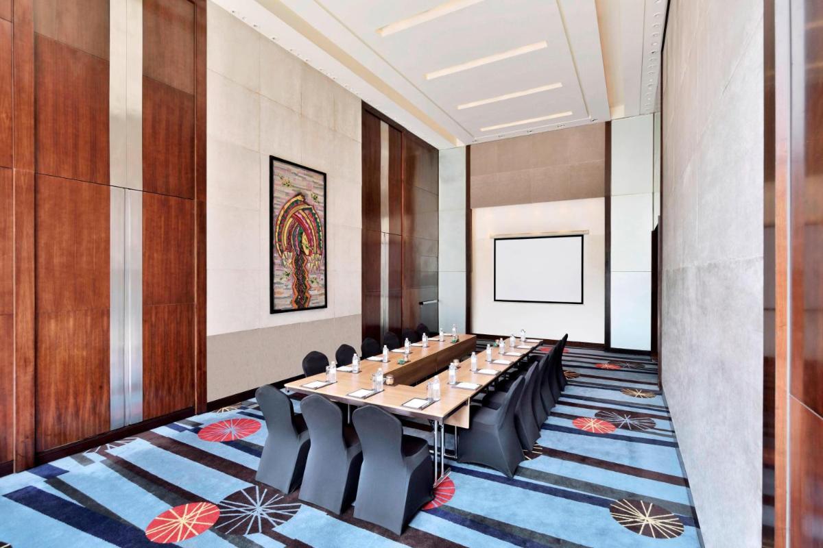 a conference room with a long table and chairs at Courtyard by Marriott Pune Hinjewadi in Pune