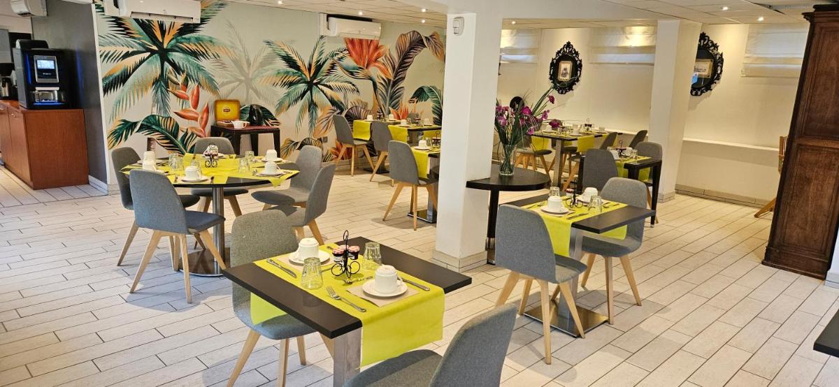 un restaurant avec des tables et des chaises dans une salle dans l'établissement Hotel SPA Plage St Jean, à La Ciotat