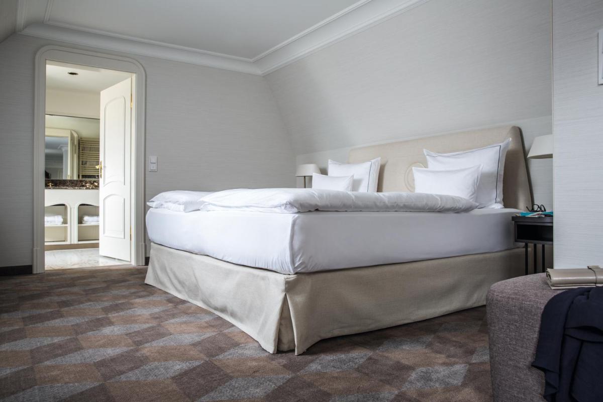 ein Schlafzimmer mit einem großen Bett mit weißer Bettwäsche in der Unterkunft Gewandhaus Dresden, Autograph Collection in Dresden