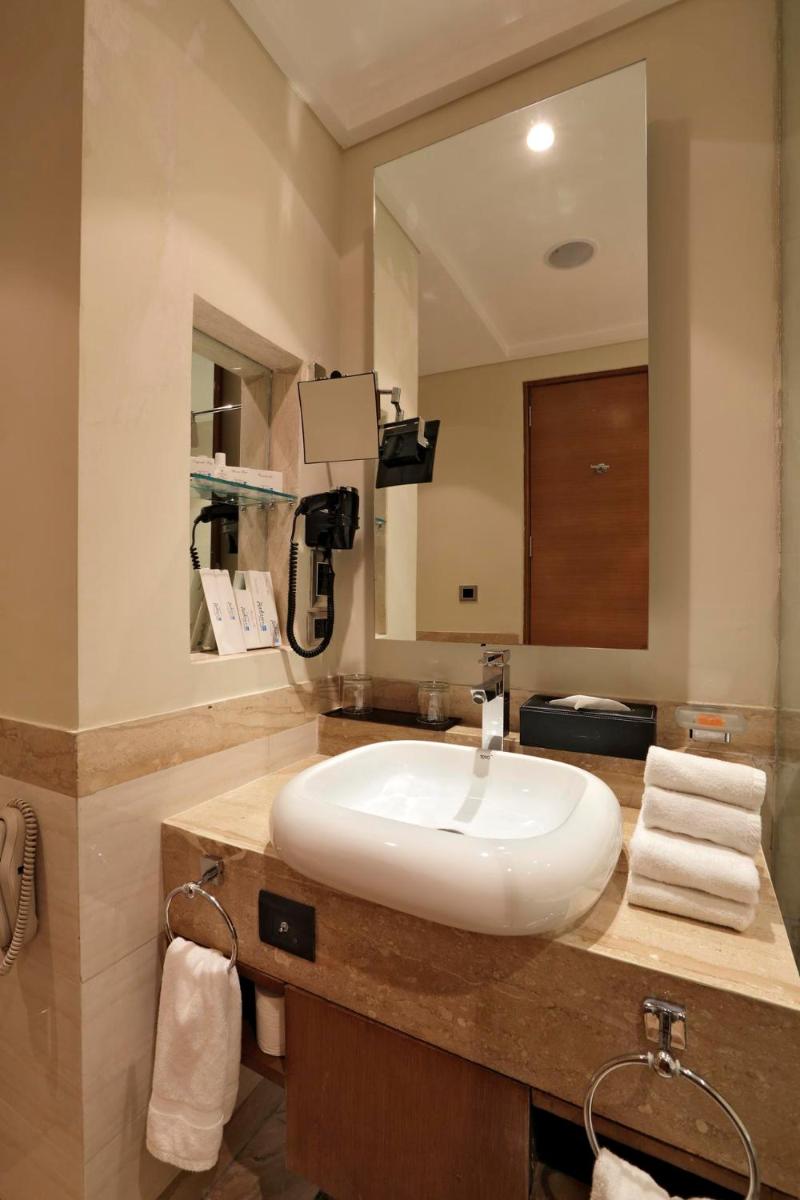 a bathroom with a white sink and a mirror at Yashail Hotel Haridwar in Haridwār