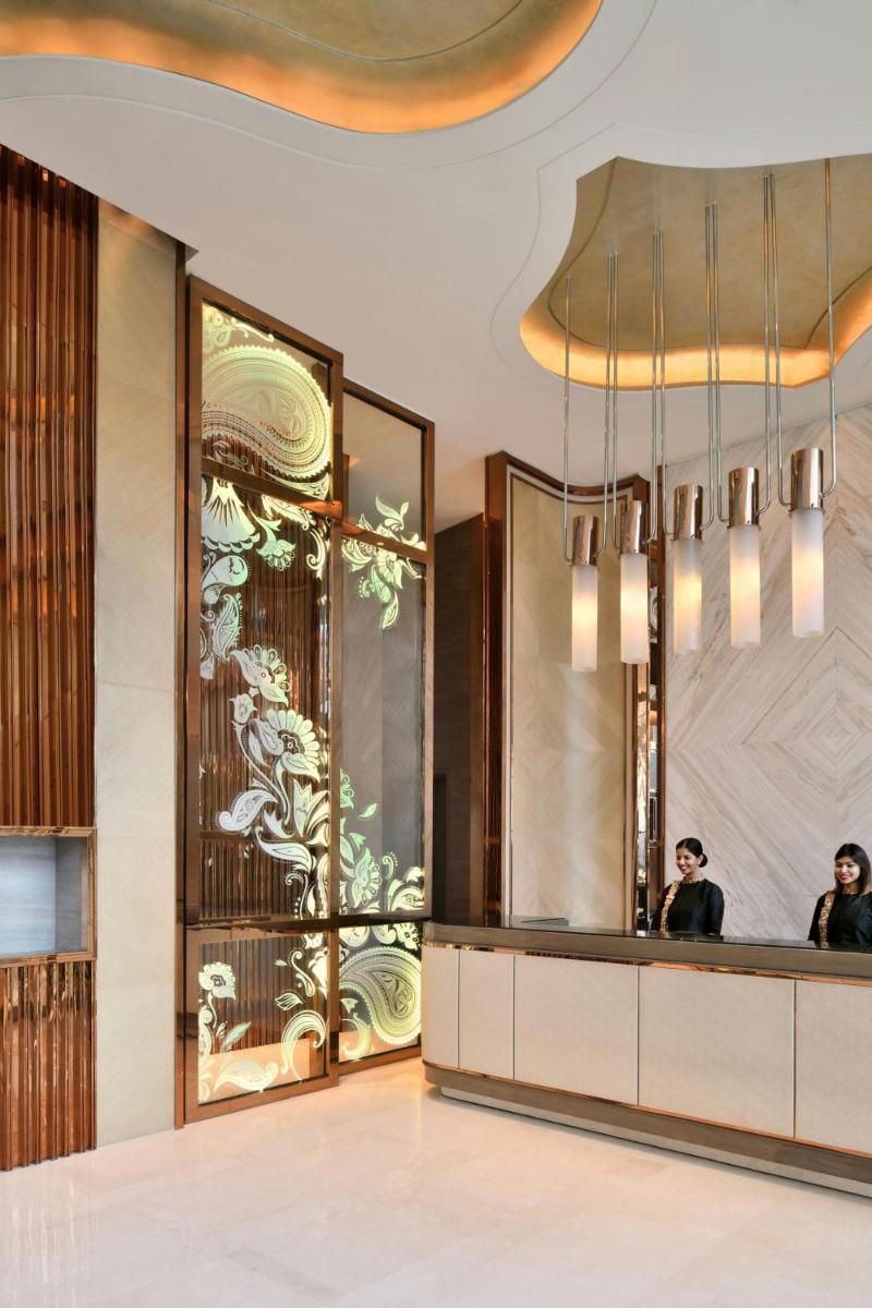 a lobby with two people sitting at a reception desk at JW Marriott Hotel Kolkata in Kolkata