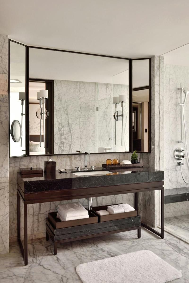 a bathroom with a sink and a large mirror at JW Marriott Hotel Kolkata in Kolkata