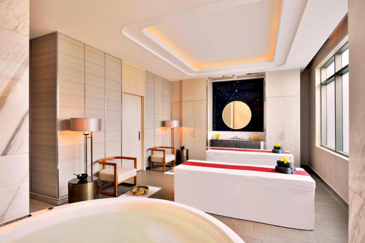 a bathroom with a tub and a bed in a room at JW Marriott Hotel Kolkata in Kolkata