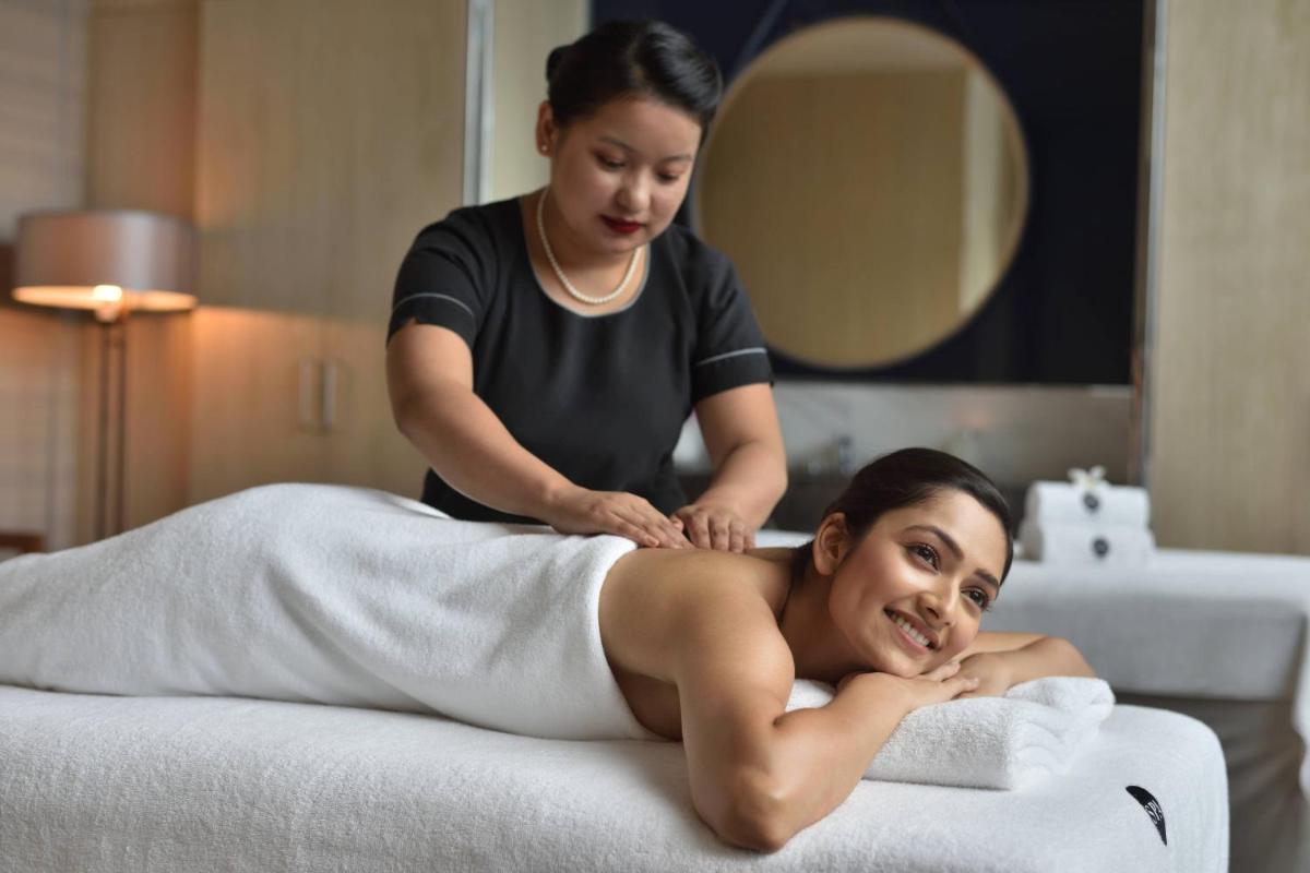 a woman getting her hair cut by a masseur at JW Marriott Hotel Kolkata in Kolkata