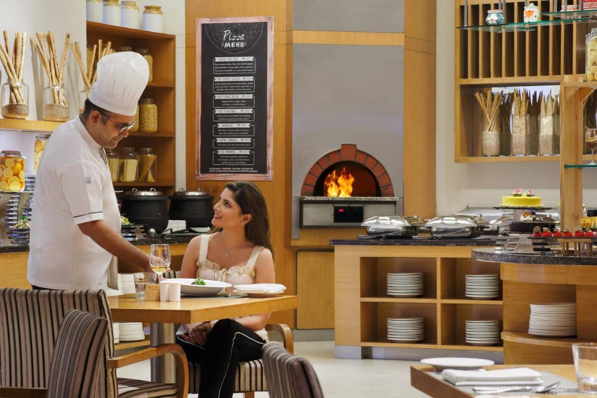 a man and a woman sitting at a table in a restaurant at Four Points by Sheraton Hotel and Serviced Apartments Pune in Pune