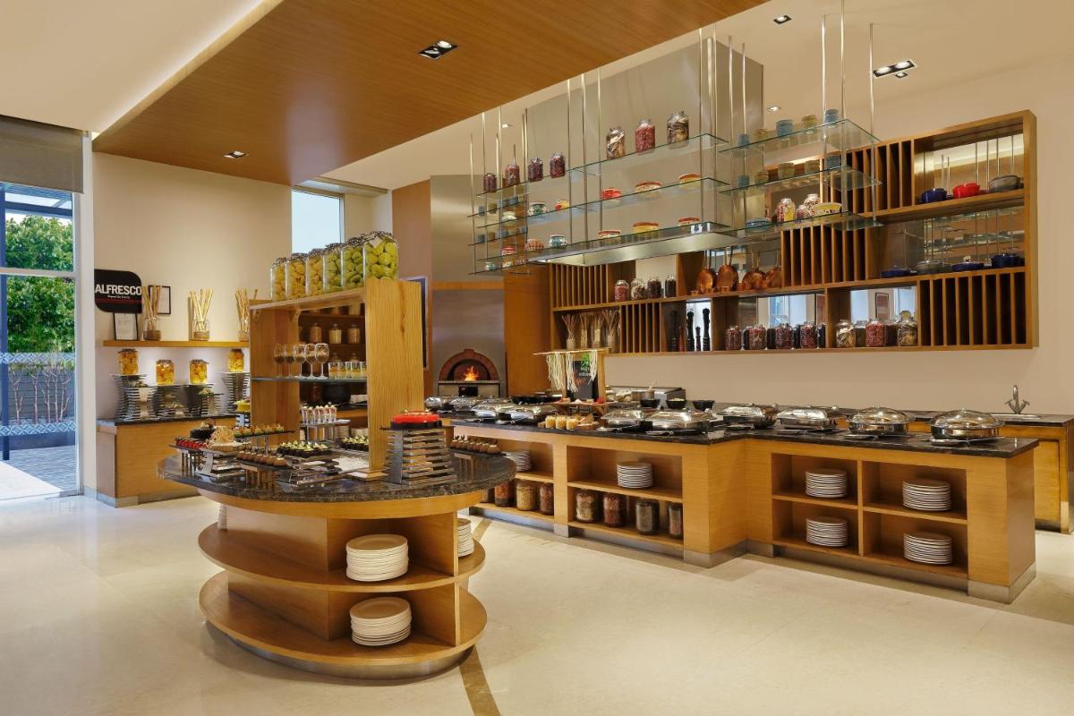 a large kitchen with a counter with pots and pans at Four Points by Sheraton Hotel and Serviced Apartments Pune in Pune