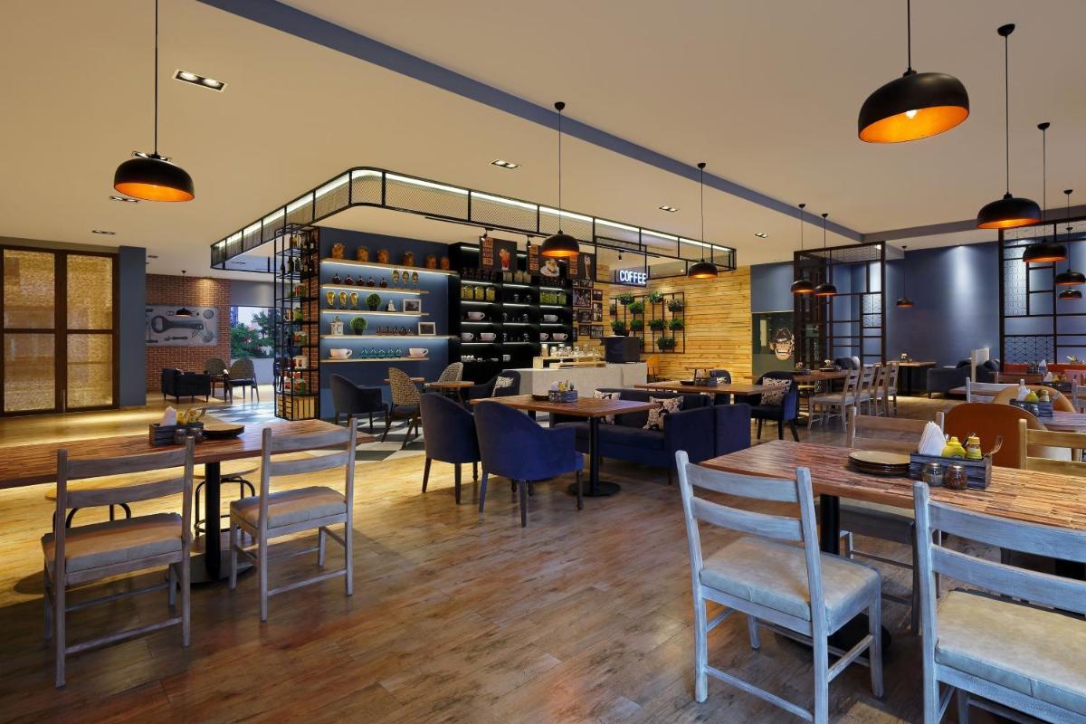 a dining room with tables and chairs and a restaurant at Four Points by Sheraton Hotel and Serviced Apartments Pune in Pune
