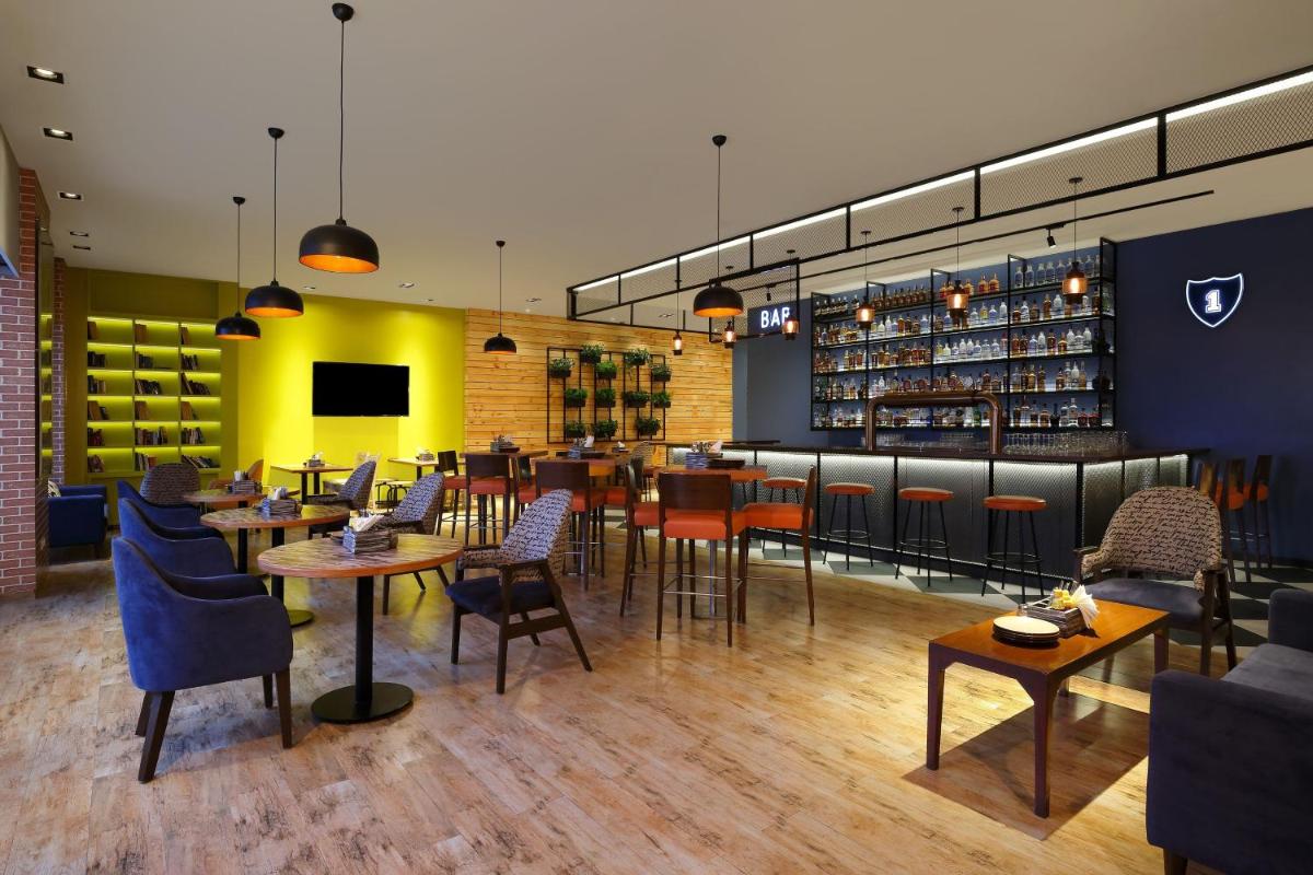 a restaurant with tables and chairs and a bar at Four Points by Sheraton Hotel and Serviced Apartments Pune in Pune