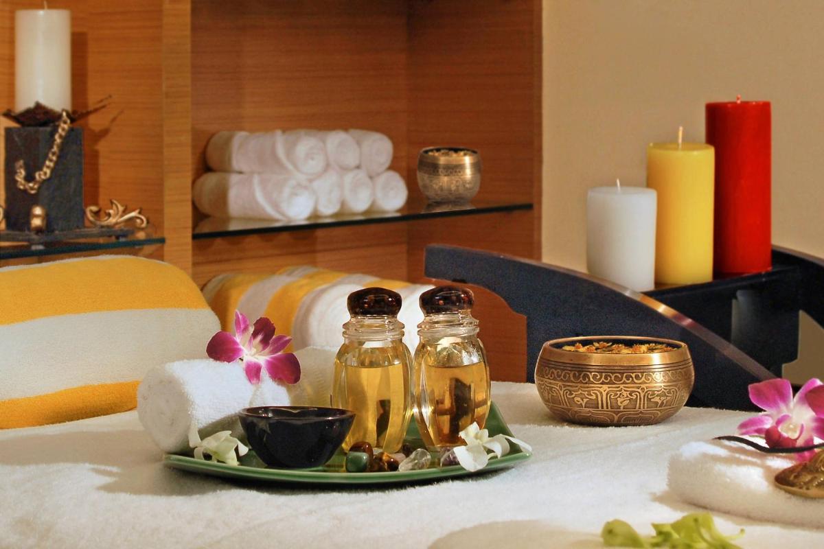 a table with a plate with a candle and two jars at Four Points by Sheraton Hotel and Serviced Apartments Pune in Pune