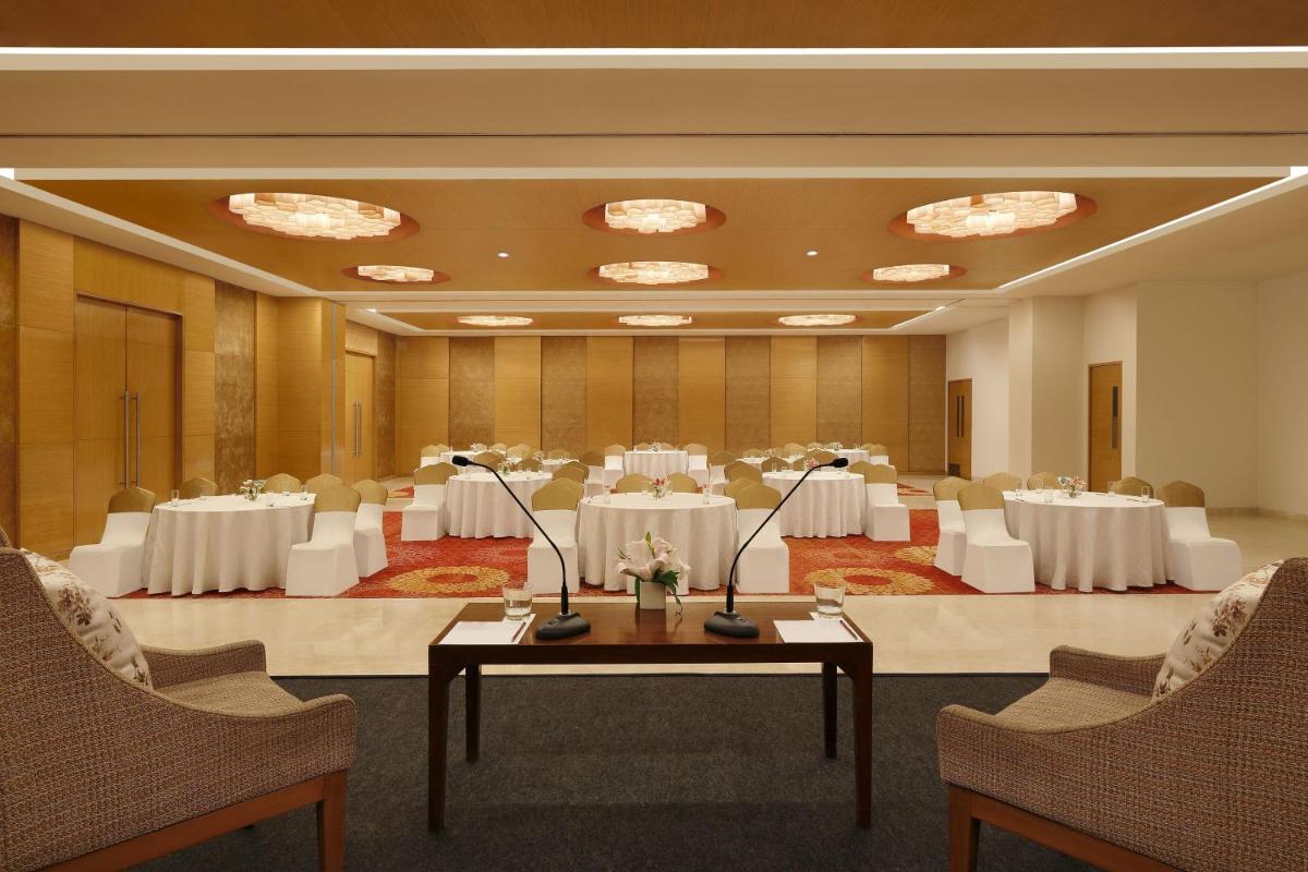 a banquet hall with white tables and chairs at Four Points by Sheraton Hotel and Serviced Apartments Pune in Pune