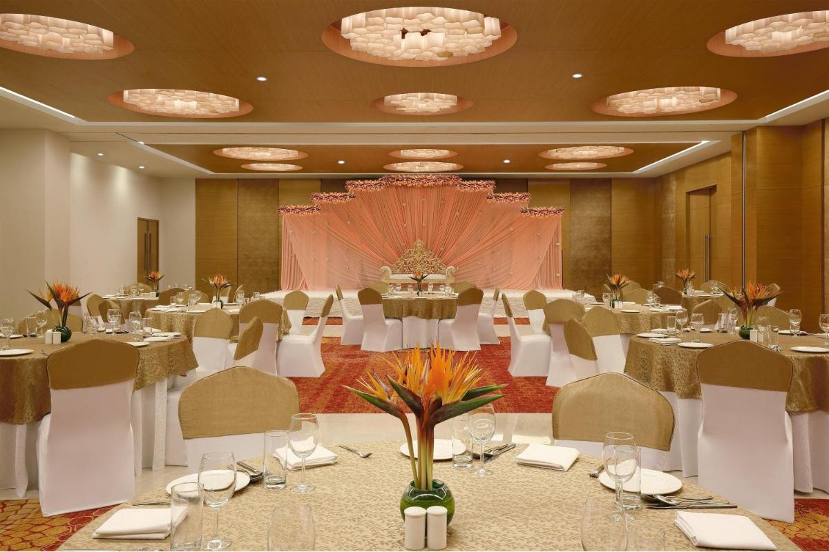 a banquet hall with tables and chairs in a room at Four Points by Sheraton Hotel and Serviced Apartments Pune in Pune +67 photos