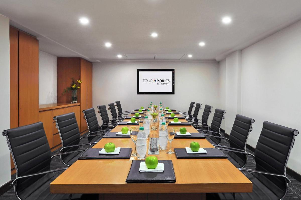 a conference room with a long table and chairs at Four Points by Sheraton Hotel and Serviced Apartments Pune in Pune