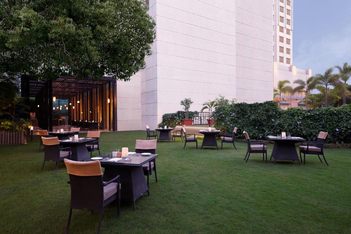 a group of tables and chairs on the grass at Four Points by Sheraton Hotel and Serviced Apartments Pune in Pune