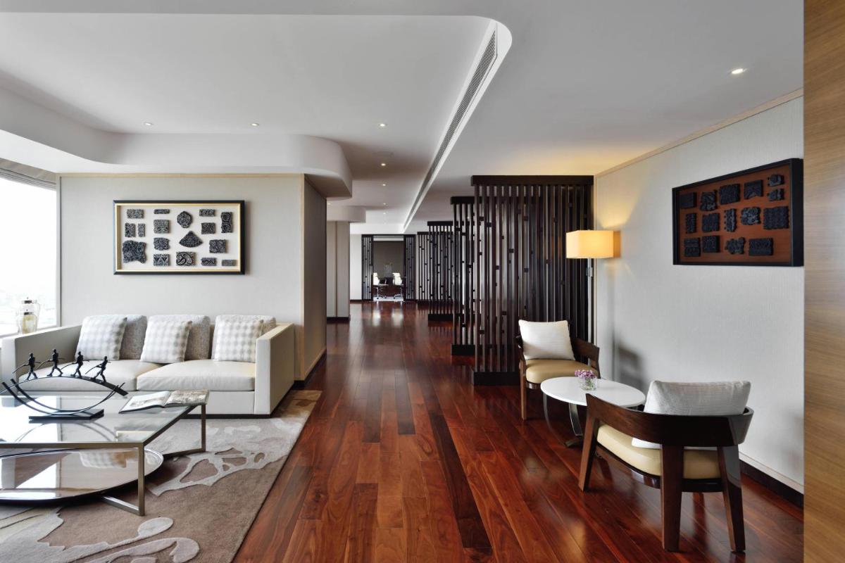 a living room with a couch and a table at Kochi Marriott Hotel in Cochin