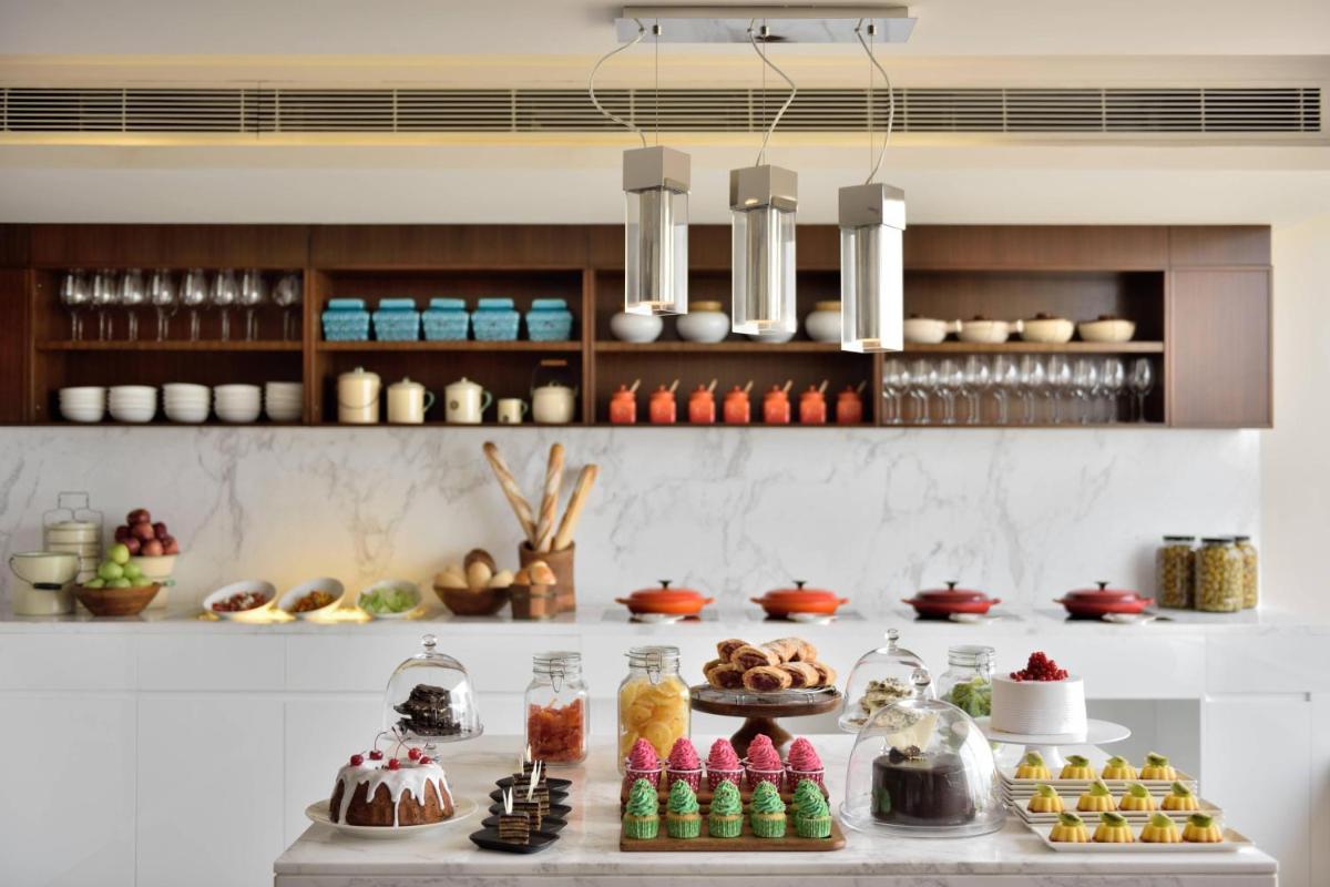 a buffet of food on a table with desserts at Kochi Marriott Hotel in Cochin