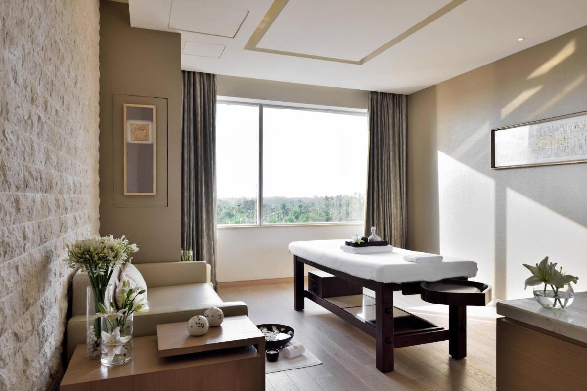 a living room with a white table and a couch at Kochi Marriott Hotel in Cochin