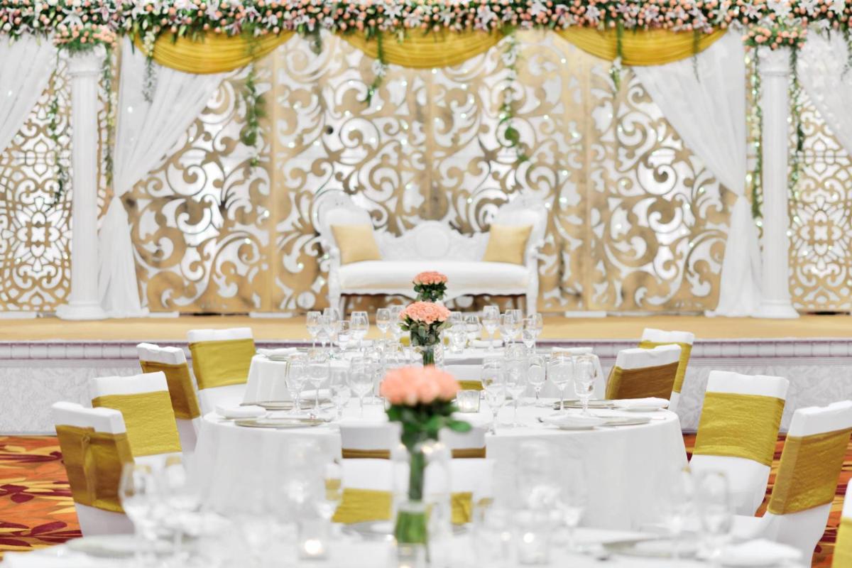 a dining room with white tables and chairs at Kochi Marriott Hotel in Cochin