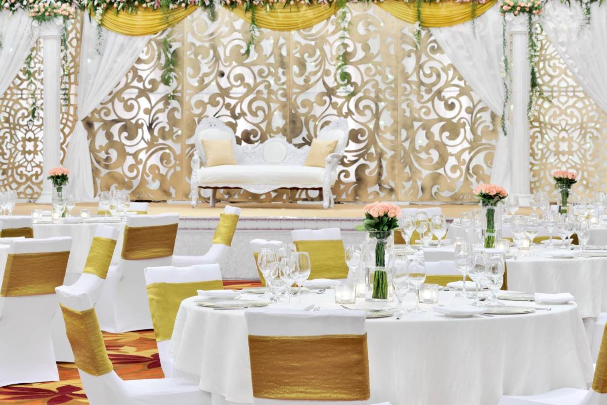 a dining room with white tables and chairs at Kochi Marriott Hotel in Cochin