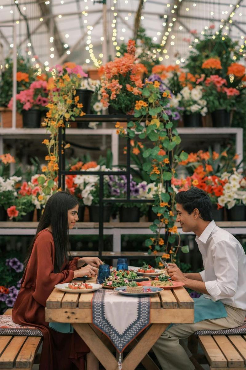 a man and woman sitting at a table in a flower shop at JW Marriott Mussoorie Walnut Grove Resort & Spa in Mussoorie