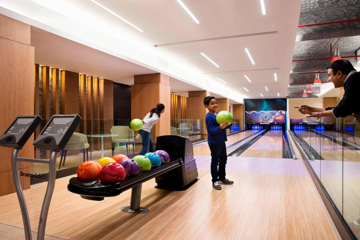 a group of people playing bowling in a bowling alley at JW Marriott Mussoorie Walnut Grove Resort & Spa in Mussoorie