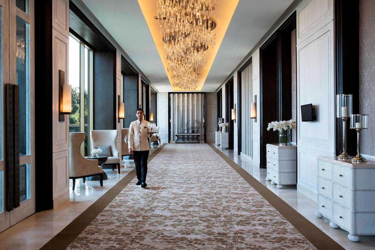 a man walking down a hallway in a hotel lobby at JW Marriott Mussoorie Walnut Grove Resort & Spa in Mussoorie