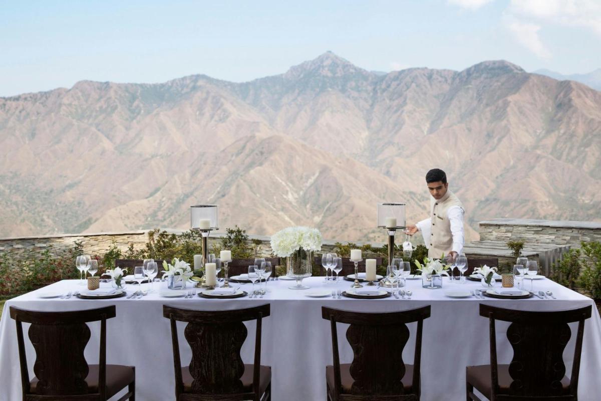 a man standing in front of a table with wine glasses at JW Marriott Mussoorie Walnut Grove Resort & Spa in Mussoorie