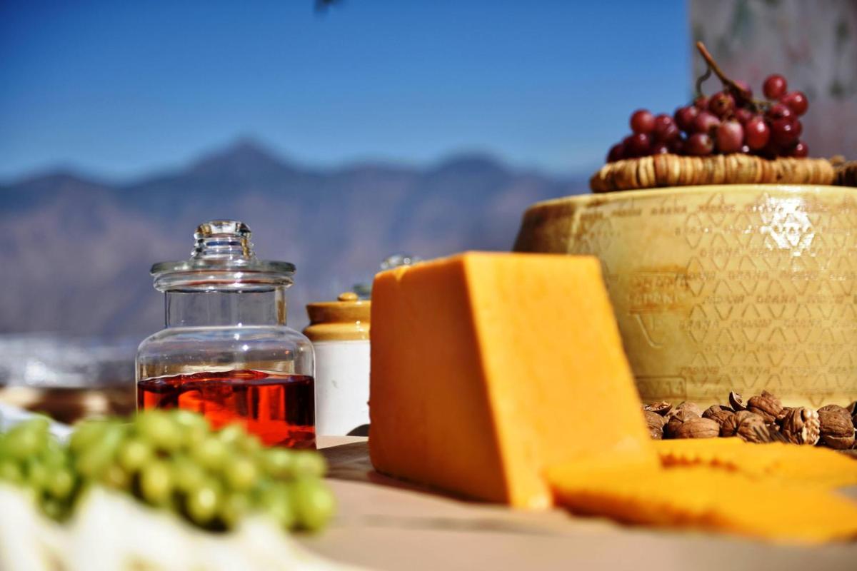 a table with a bottle of wine and a book and grapes at JW Marriott Mussoorie Walnut Grove Resort & Spa in Mussoorie