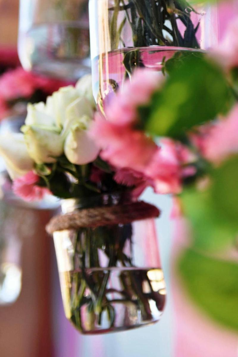 a glass vase filled with pink and white flowers at JW Marriott Mussoorie Walnut Grove Resort & Spa in Mussoorie