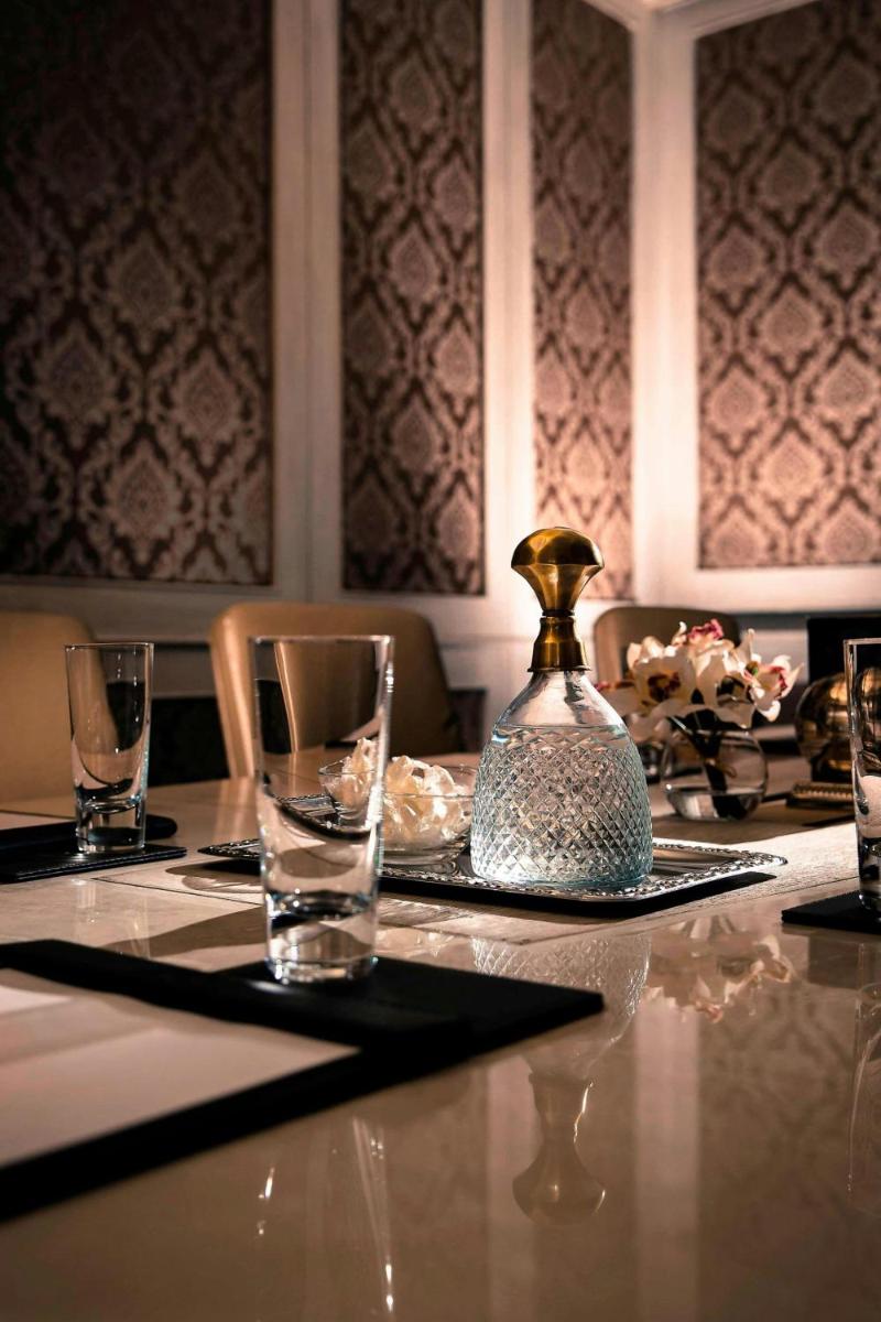 a table with glasses and a bottle on top of it at JW Marriott Mussoorie Walnut Grove Resort & Spa in Mussoorie