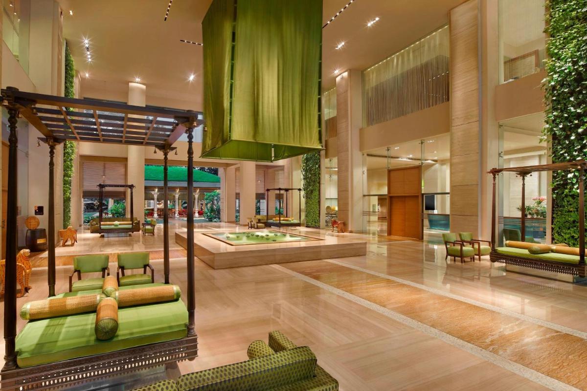 a lobby with green furniture in a building at ITC Gardenia, a Luxury Collection Hotel, Bengaluru in Bengaluru a lobby with green furniture in a building at ITC Gardenia, a Luxury Collection Hotel, Bengaluru in Bengaluru