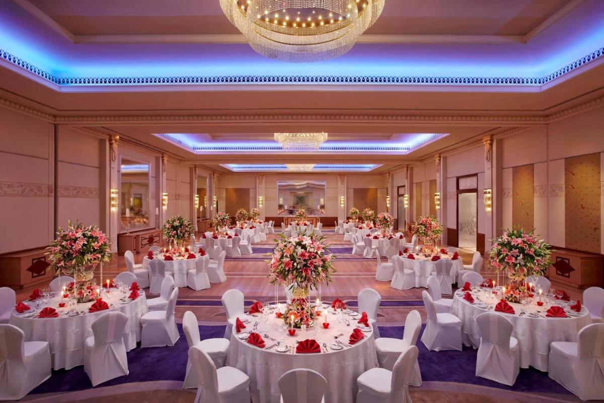 a banquet hall with white tables and white chairs at ITC Gardenia, a Luxury Collection Hotel, Bengaluru in Bengaluru a banquet hall with white tables and white chairs at ITC Gardenia, a Luxury Collection Hotel, Bengaluru in Bengaluru