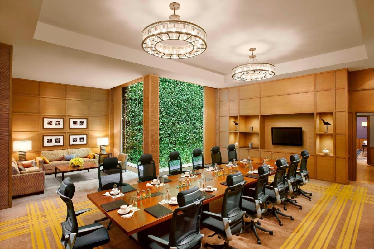 a conference room with a long table and chairs at ITC Gardenia, a Luxury Collection Hotel, Bengaluru in Bengaluru a conference room with a long table and chairs at ITC Gardenia, a Luxury Collection Hotel, Bengaluru in Bengaluru