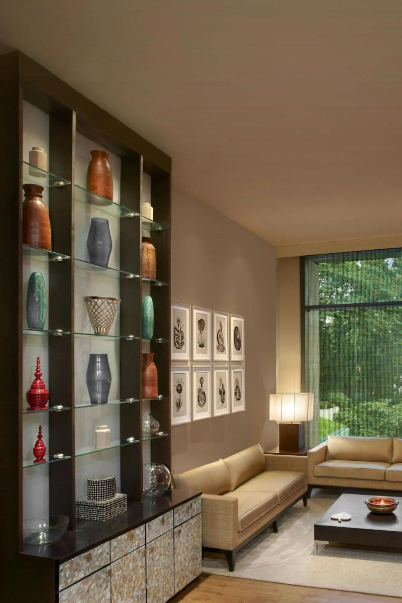 a living room with a couch and shelves with vases at ITC Gardenia, a Luxury Collection Hotel, Bengaluru in Bengaluru a living room with a couch and shelves with vases at ITC Gardenia, a Luxury Collection Hotel, Bengaluru in Bengaluru