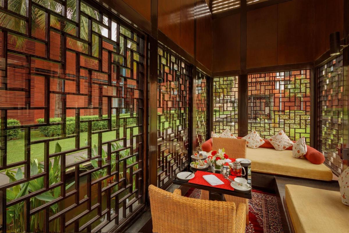 a room with stained glass windows and a table and chairs at ITC Sonar, a Luxury Collection Hotel, Kolkata in Kolkata