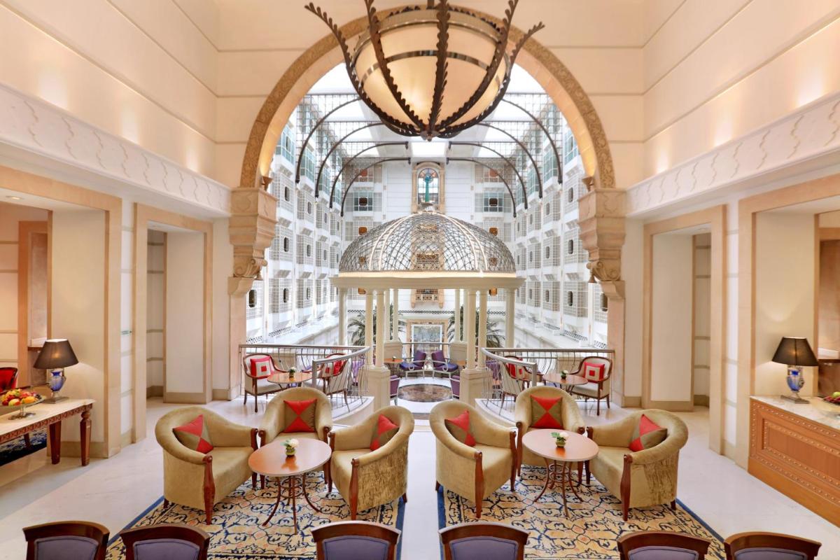 a large lobby with tables and chairs and a chandelier at ITC Maratha, a Luxury Collection Hotel, Mumbai in Mumbai