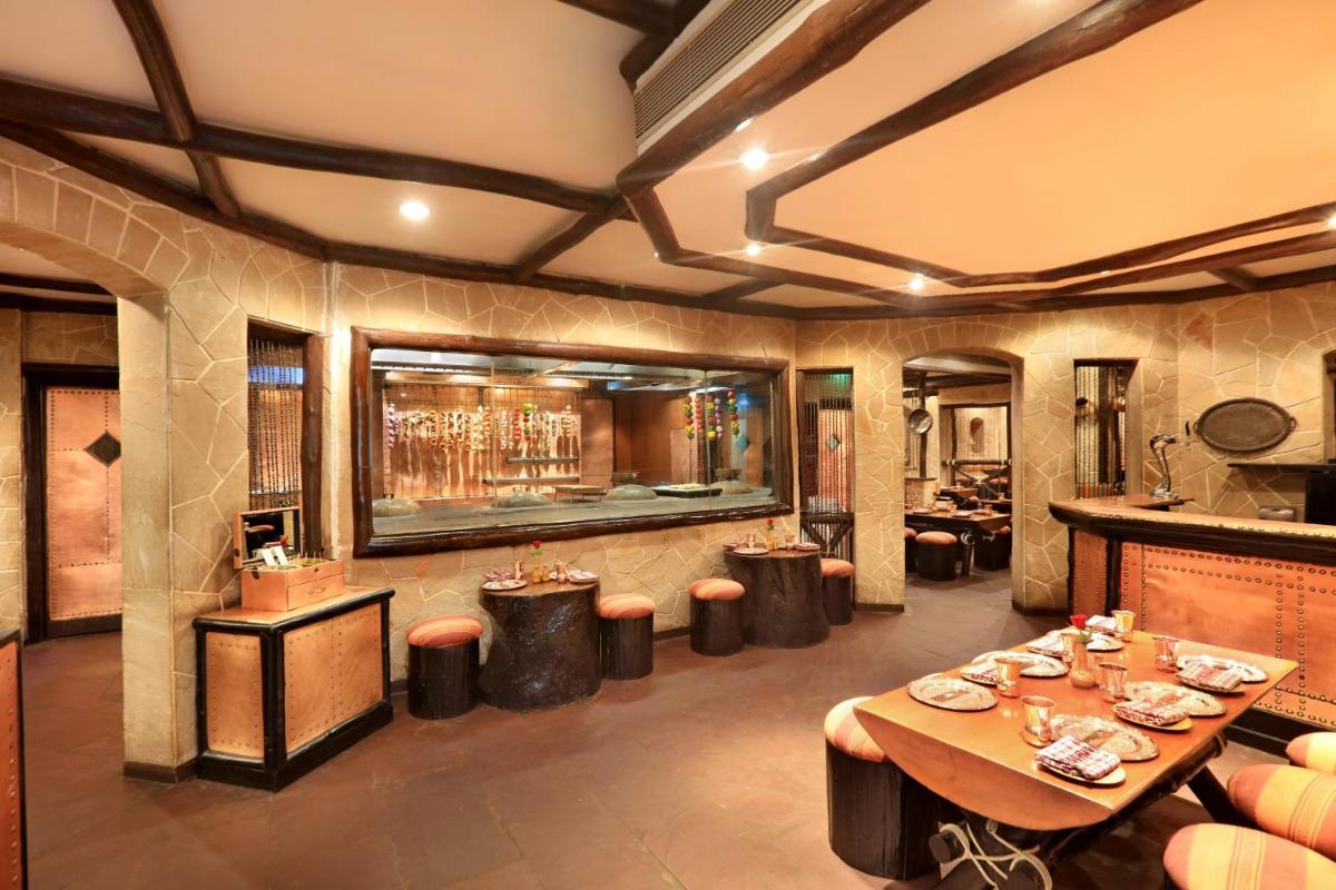 a restaurant with tables and stools in a room at ITC Maratha, a Luxury Collection Hotel, Mumbai in Mumbai
