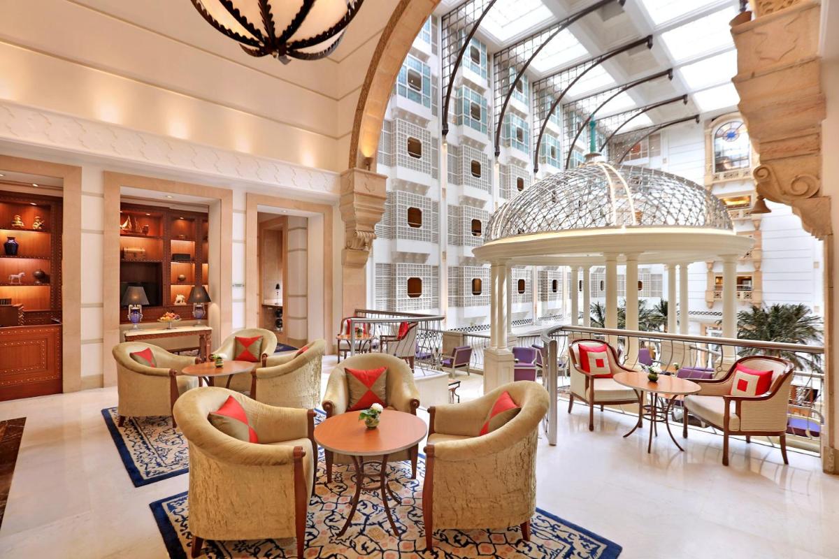 a lobby of a hotel with tables and chairs at ITC Maratha, a Luxury Collection Hotel, Mumbai in Mumbai