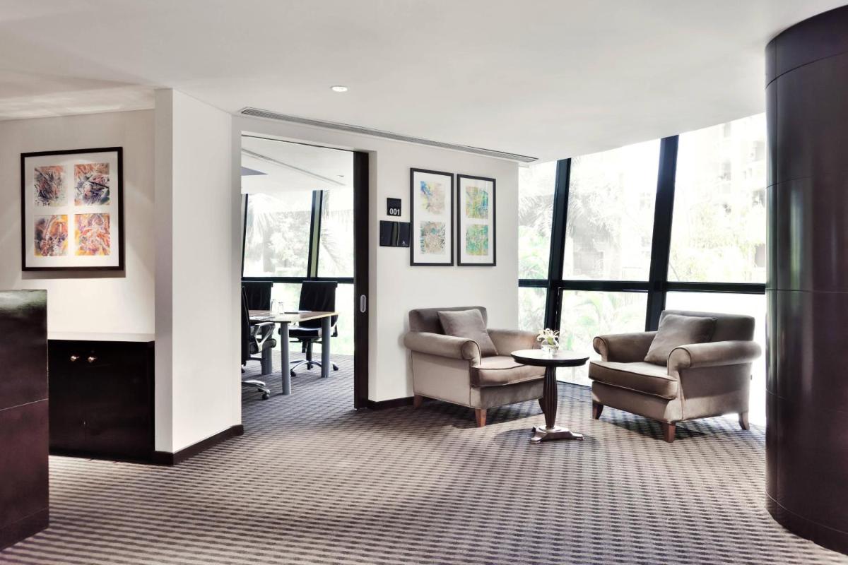 a living room with two chairs and a table at Marriott Suites Pune in Pune