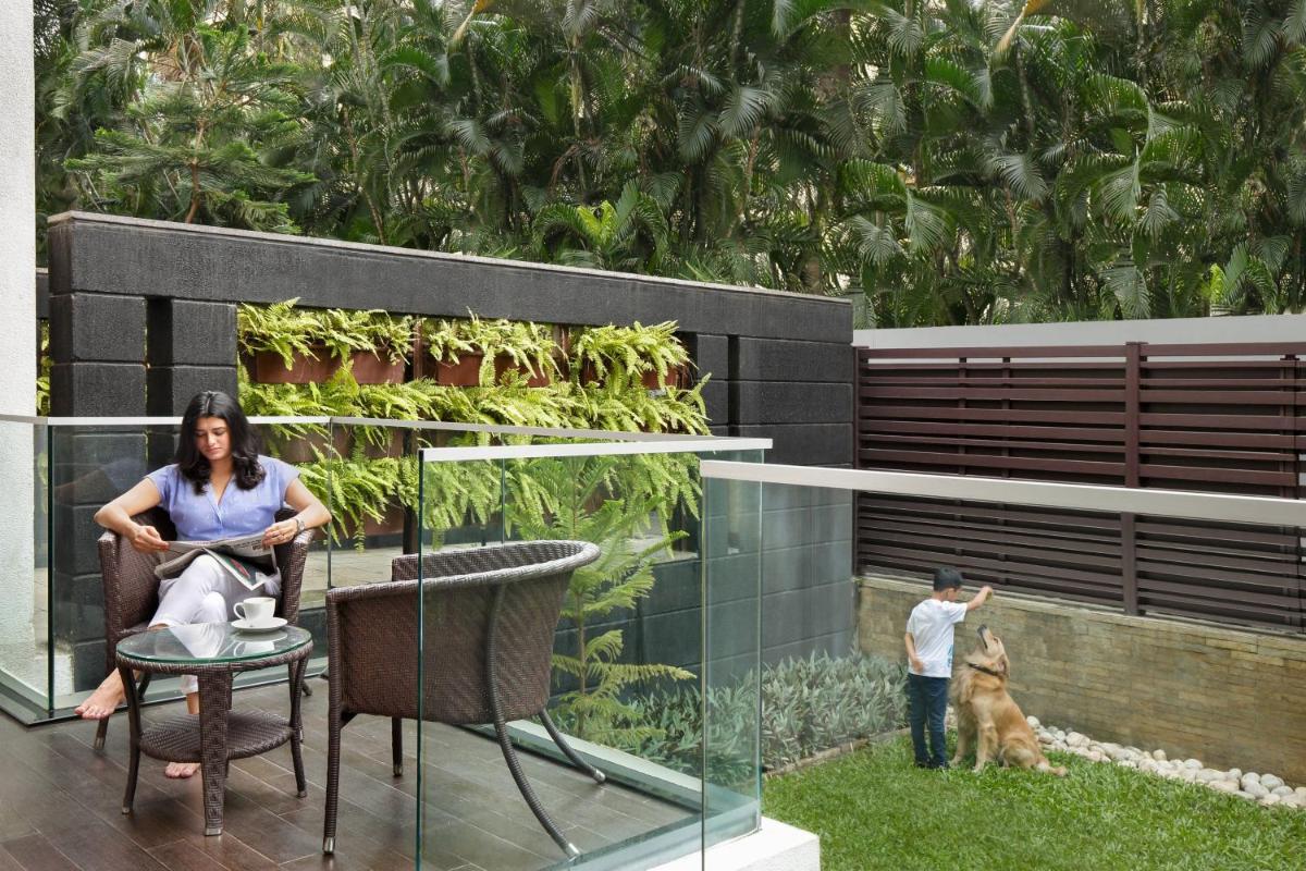 a woman sitting in a chair next to a dog at Marriott Suites Pune in Pune
