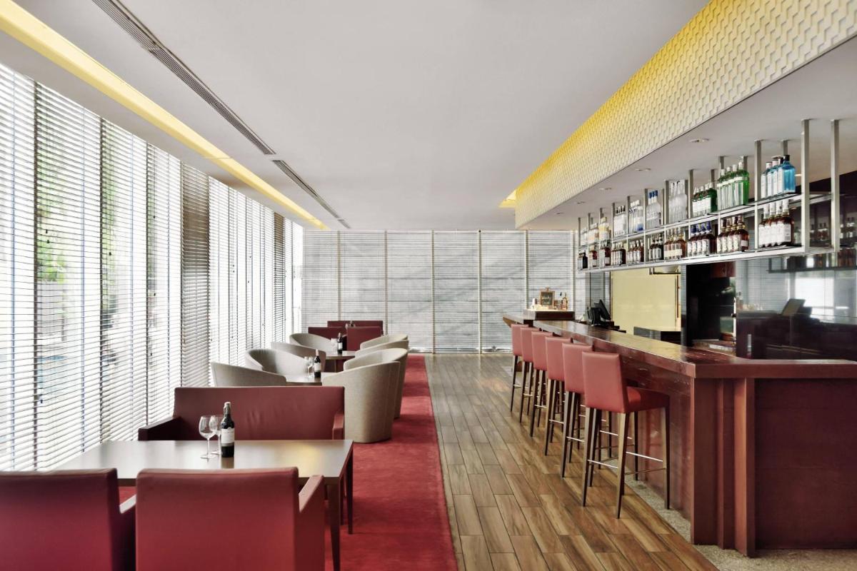 a restaurant with tables and chairs and a bar at Marriott Suites Pune in Pune