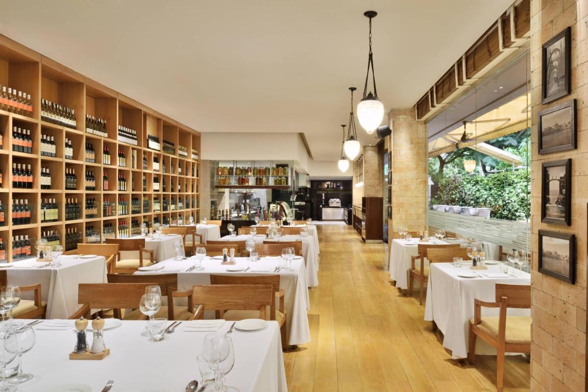 a dining room with white tables and chairs at Marriott Suites Pune in Pune
