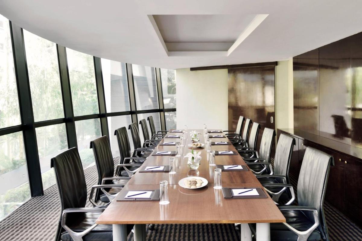 a long dining room with a long table and chairs at Marriott Suites Pune in Pune