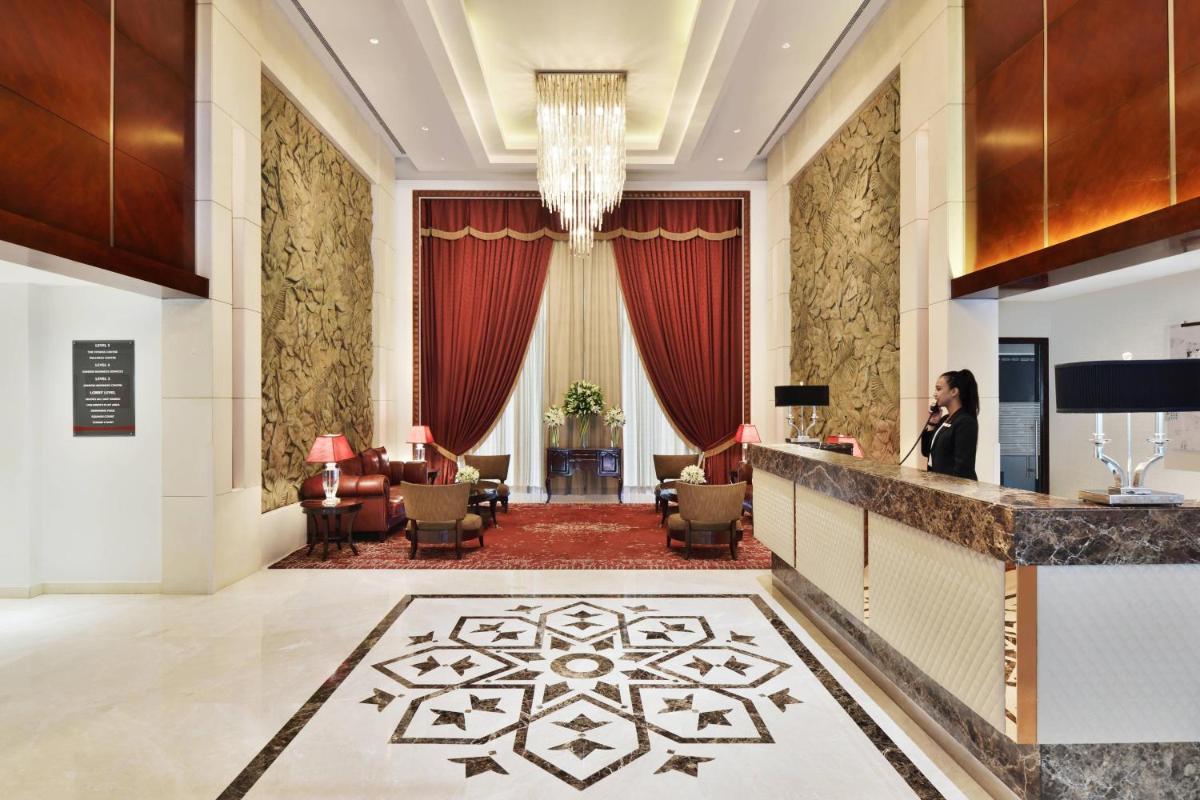 a hotel lobby with a woman talking on a phone at Marriott Suites Pune in Pune