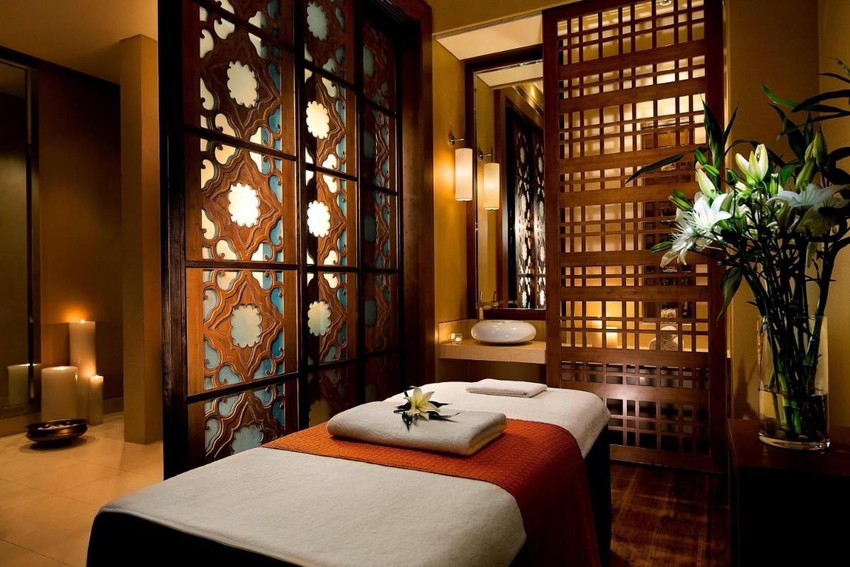 a hotel room with two beds and a mirror at JW Marriott Pune in Pune