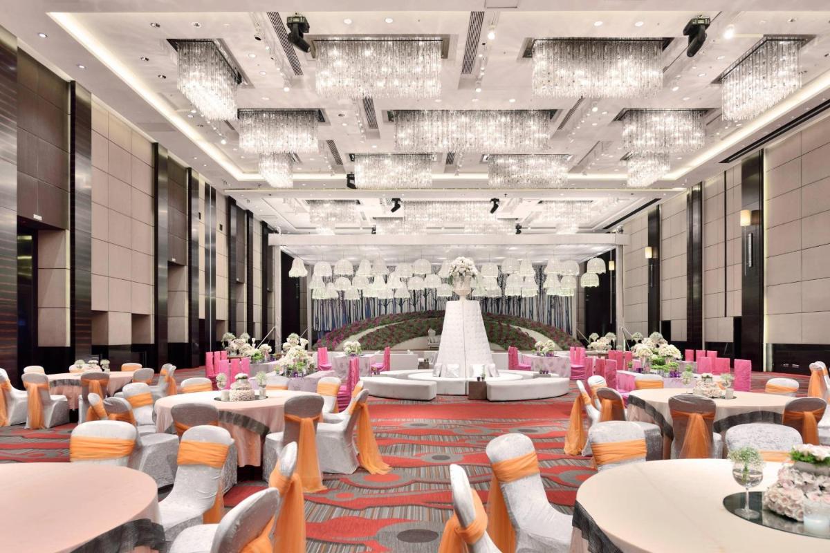 a banquet hall with tables and chairs and a wedding cake at JW Marriott Pune in Pune +55 photos