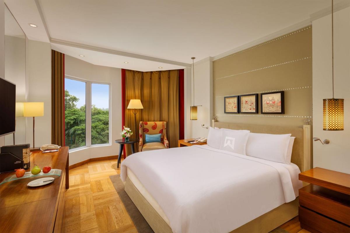 a bedroom with a large white bed and a desk at ITC Maurya, a Luxury Collection Hotel, New Delhi in New Delhi a bedroom with a large white bed and a desk at ITC Maurya, a Luxury Collection Hotel, New Delhi in New Delhi