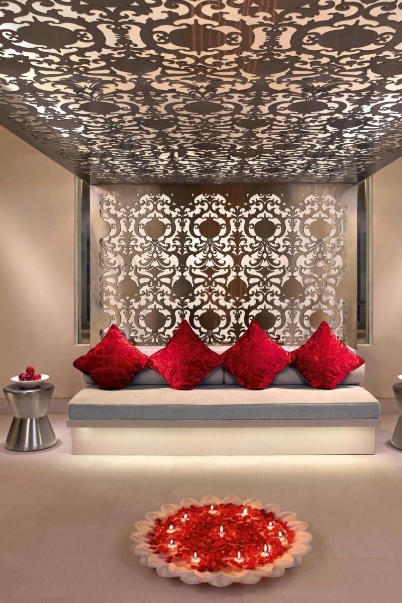 a room with a couch with red pillows and a table at ITC Maurya, a Luxury Collection Hotel, New Delhi in New Delhi a room with a couch with red pillows and a table at ITC Maurya, a Luxury Collection Hotel, New Delhi in New Delhi