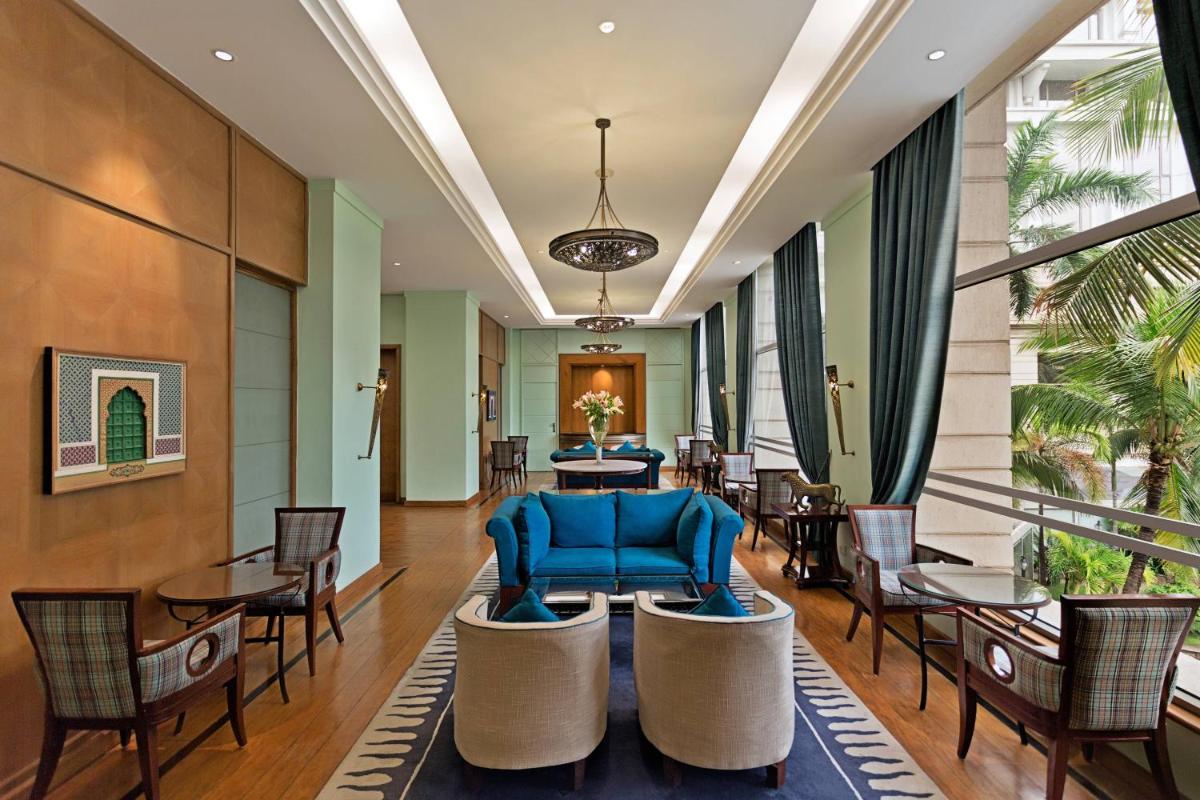 a lobby with a blue couch and chairs at ITC Kakatiya, a Luxury Collection Hotel, Hyderabad in Hyderabad