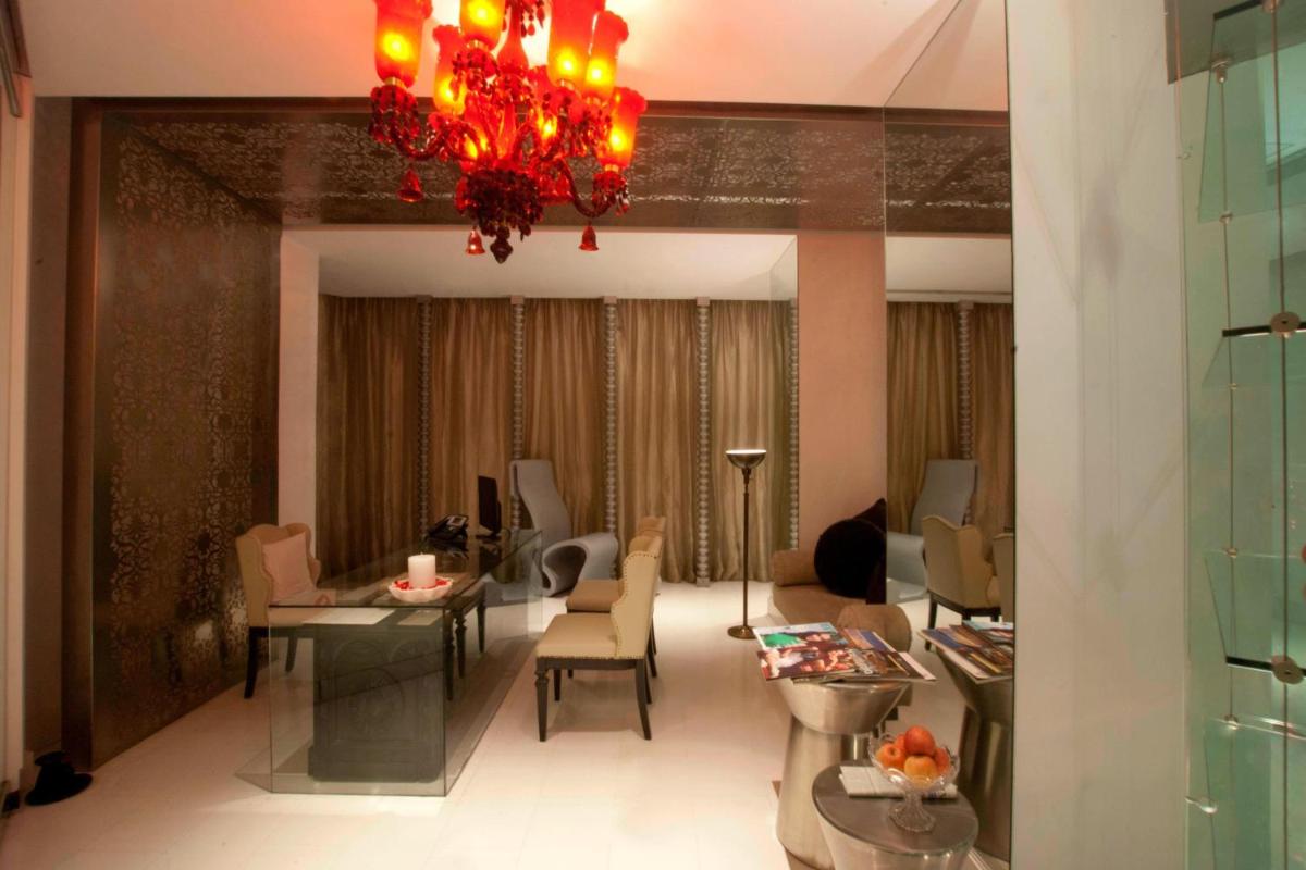 a living room with a chandelier and a table and chairs at ITC Kakatiya, a Luxury Collection Hotel, Hyderabad in Hyderabad